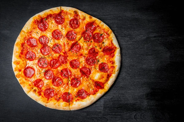  Klasik İtalyan pepperonili pizza. Siyah arka planda.