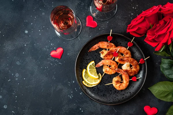  Kızarmış karides, güller ve şampanya. Sevgililer Günü için orijinal aperatif, romantik akşam yemeği. Üst görünüm, metin için boş alan. Yüksek kalite fotoğraf