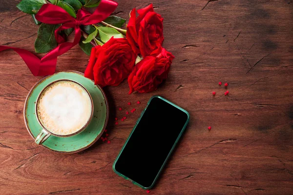  Bir fincan kahve, kırmızı güller ve içerik için boş yeri olan bir telefon.