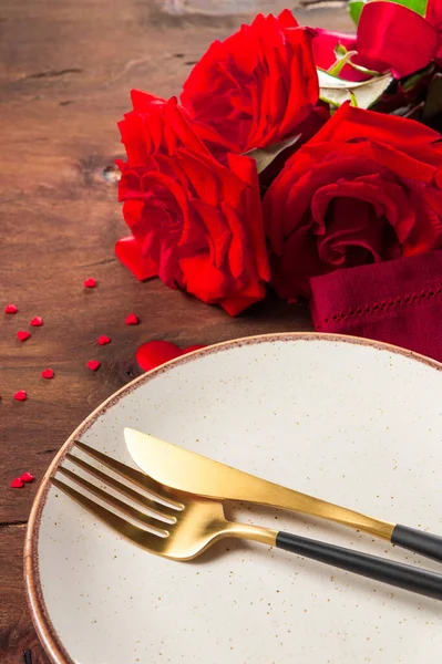  Tabak, çatal bıçak ve güller, romantik yemek konsepti. Dikey fotoğraf