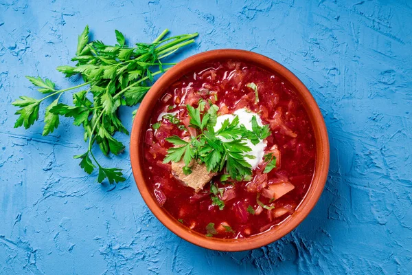 Mavi arka planda ekşi kremalı borş, üst manzara - bir tabak geleneksel Rus ve Ukrayna mutfağı