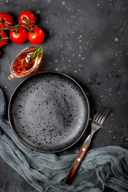  Boş tabak, çatal, domates ve yağ soslu sandal, siyah arka plan manzaralı.