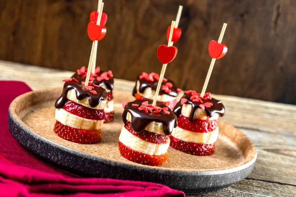  Muz ve çilekli kanepeler bir tabakta çikolata, Sevgililer Günü için orijinal bir aperatif. Yüksek kalite fotoğraf