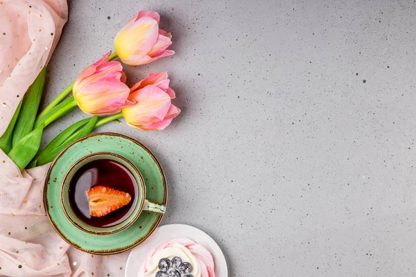  Çilekli çay, gri arka planda Pavlova pastası ve pembe laleler, kopyalanmış fotoğraf.