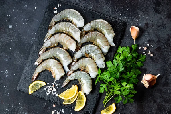  Koyu gri arka plan görünümlü sarımsak ve limonlu çiğ karides.