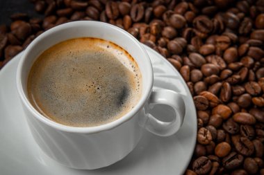  Bir fincan sade kahve ve kavrulmuş kahve çekirdekleri yakın. Yüksek kalite fotoğraf