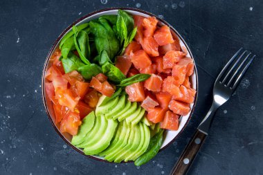  Karbonhidrat Bedava Keto Diyet Kasesi. Ispanak, somon, avokado ve domatesler yakın plandaki masada, üst tarafta. Yüksek kalite fotoğraf