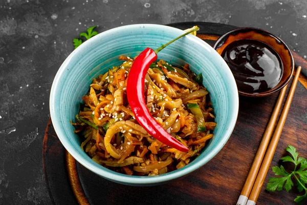 전통적 인 아시아 식 식욕을 돋우는 샐러드 나무 판위에 놓인 접시에 야채를 곁들인 매운 오징어 샐러드 와 가까이 있는 짙은 회색 배경 — 스톡 사진