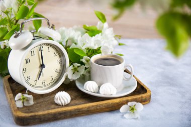  Beyaz çalar saat ve bir buket beyaz elma çiçeği ve masada bir fincan kahve, yaz sabahı konsepti. Metin için boş alan