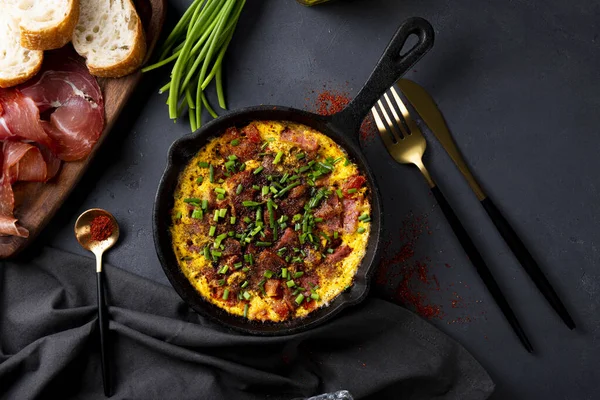 Egg omelet with sausage and seasonings in a cast iron pan top view