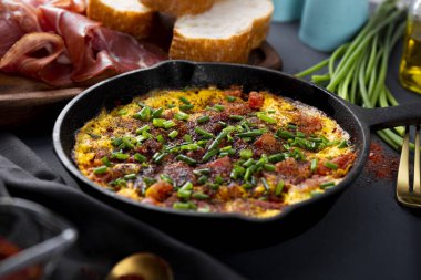 Yumurtalı omlet, sosis ve baharatlar dökme demir tavada, yakın çekim, yumuşak odaklı.