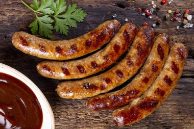  Izgara kıyma ve ahşap tahtada barbekü soslu domuz sosisi.