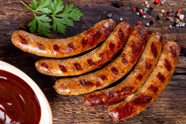  Izgara kıyma ve ahşap tahtada barbekü soslu domuz sosisi.