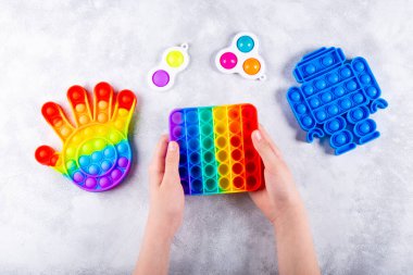 Çocukların eli yeni moda bir silikon oyuncağı çalıyor. Stres önleyici, diğer oyuncakların yanına koy ve basit bir gamzeyle patlat. Üst görünüm
