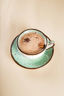 Bir fincan Masala çayı. Dikey bir fotografta sütle baharatlı geleneksel Hint çayı.