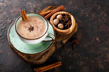 Masala çayı. Koyu arka planda bir fincanda sütlü ve baharatlı geleneksel Hint çayı metin için kopyalama alanı