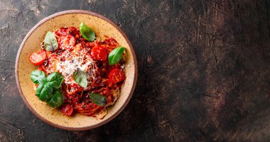 Domates soslu İtalyan makarnası, domates, peynir ve fesleğen, arka planda koyu bir üst görünüm, metin alanı için internet afişi