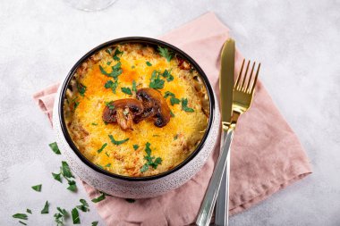 Patates ve mantarlı Julienne hafif bir arka planda fırın kabında. Geleneksel Fransız yemeği