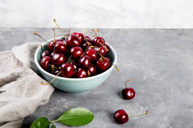 Açık gri arka planda olgun bir kiraz, masada yaz meyveleri metin için fotokopi alanı