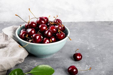 Açık gri arka planda olgun bir kiraz, masada yaz meyveleri metin için fotokopi alanı