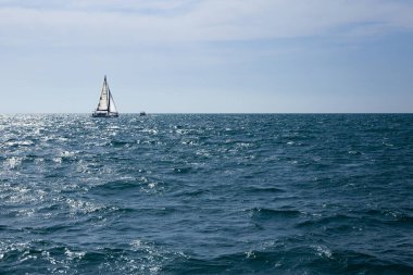  Güneşli bir günde Ufukta bir yelkenli