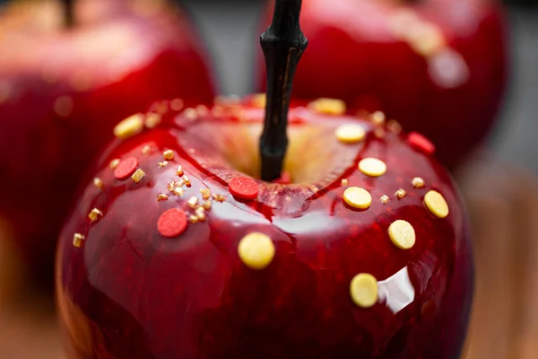 Красные яблоки в карамели с сахарным декором, оригинальное угощение для праздничного стола Хэллоуин крупным планом, мягкий фокус — стоковое фото