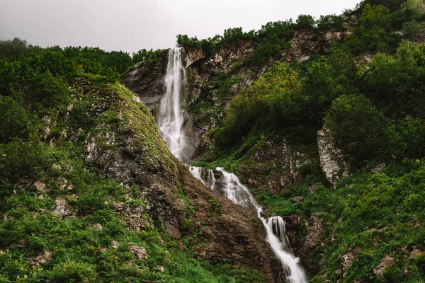 Hermosa cascada de montaña entre árboles, fondo natural de verano — Foto de Stock