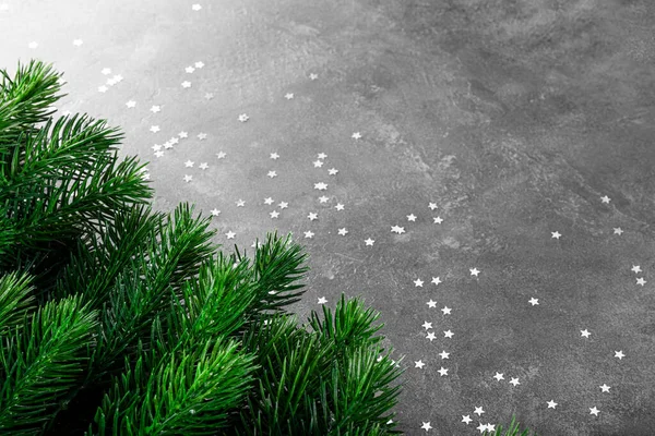Φλάφι πράσινο έλατο κλαδιά και ασημένια αστέρια σε γκρι φόντο, Χριστούγεννα έννοια με ελεύθερο χώρο για κείμενο — Φωτογραφία Αρχείου