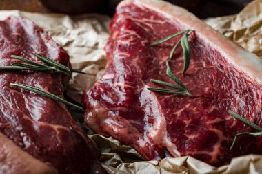  Çiğ mermer biftekler ve eski ahşap arka plandaki hazırlıkları için baharatlar. Mutfak masasında çiğ et. Yüksek kalite fotoğraf