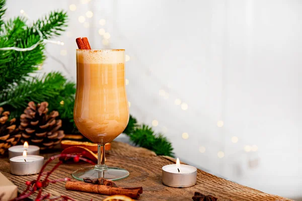 Un vaso de bebida tradicional de Navidad ponche de huevo en una mesa festiva, copia el espacio para el texto. Bebida picante hecha de huevo y leche con canela, cardamomo. — Foto de Stock