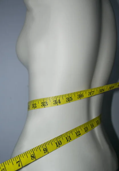 带子尺寸在瘦小的身体上 白色的人体模特 控制体重饮食和苗条腰围的概念 — 图库照片