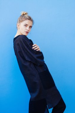 bir kız mavi duvara karşı ayakta