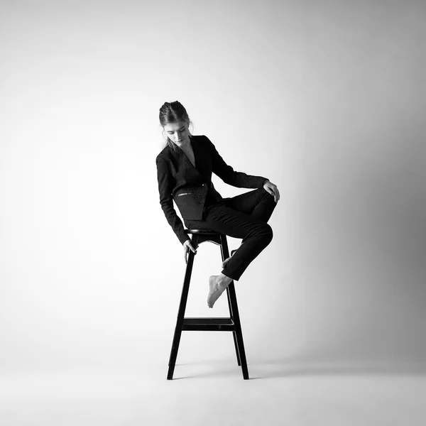 Dívka v kroji, sedí na židli — Stock fotografie