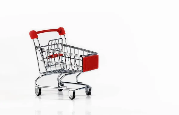 Beyaz arka planda kırmızı eklenmiş boş bir süpermarket arabası.