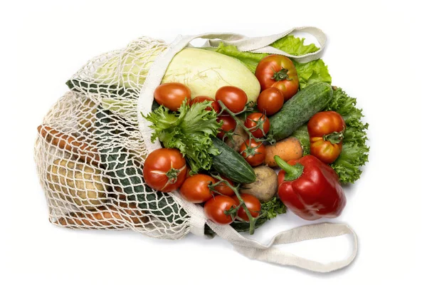 Légumes dans une grille réutilisable sur fond blanc, vue du dessus. — Photo