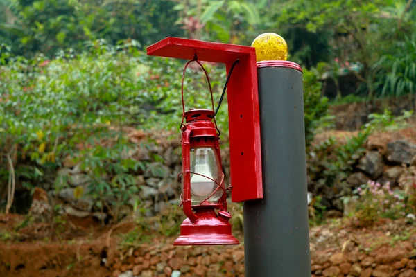 Red color electric lamp hanging on a pillar, imitation of traditional lamp