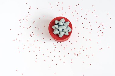 Kırmızı hediye kutusu ya da beyaz arka planda parıltılı gümüş yay ile izole kırmızı hediye kutusu. Noel süsü. Sevgililer Günü.