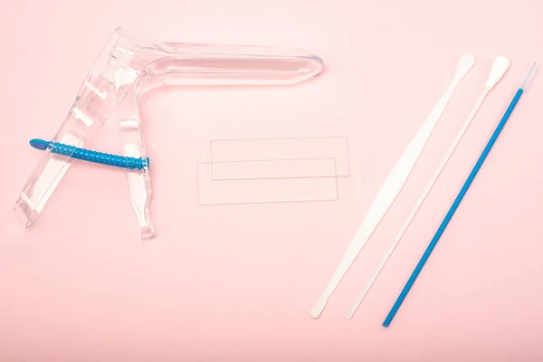 Disposable gynecological examination kit on a pink background. Gynecological examination set. The view from the top. Gynecological clinic.