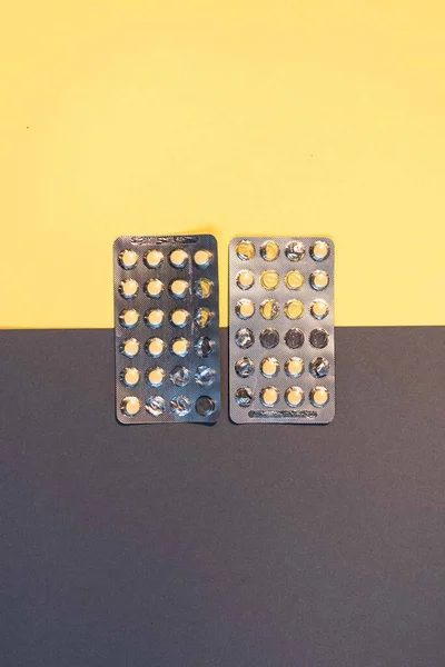 薬黄色の丸い錠剤 錠剤は黄色と灰色の背景に抽象的に配置しました アスピリン アンプル 薬の丸薬とバイアルと医療注射器 — ストック写真