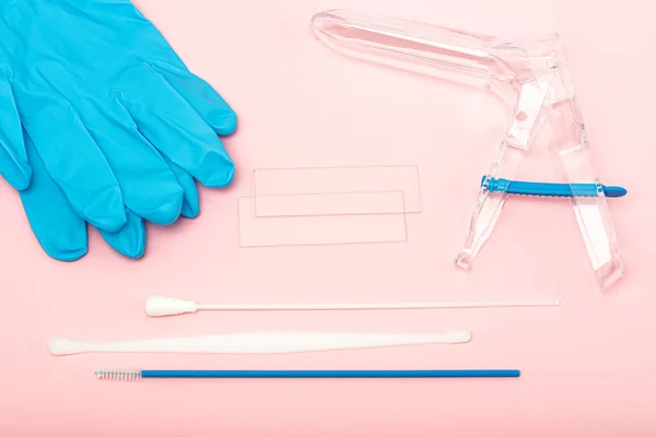 Disposable gynecological examination kit on a pink background. Gynecological examination set. The view from the top. Gynecological clinic.