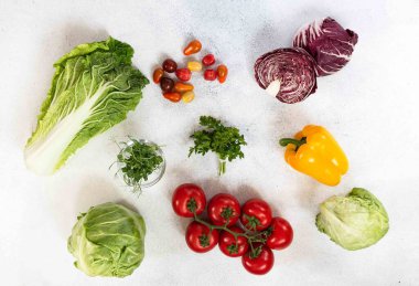 Organik vejetaryen yemeği. Taş zeminde sebzeler ve fotokopi alanı. Domates, bezelye filizi, maydanoz, dolma biber, mor radicchio, yeşil lahana, napa lahanası, Çin lahanası. Sağlıklı malzemeler.