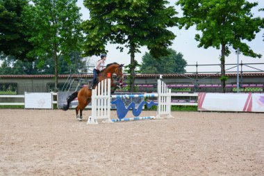 Ritim ve atlama anında binicinin ve atın konumunu gösteren bir kursta atlama dersi göster