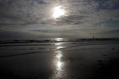 Güneş, kuzey sahilindeki gri bulutların arasından kendi yolunu çizer.