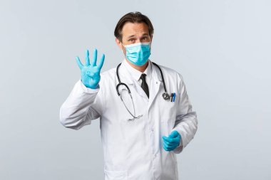 Covid-19, virüsü önleme, sağlık çalışanları ve aşı konsepti. Klinikteki profesyonel doktor, tıbbi maske ve eldiven takarak sağlığını enfeksiyondan korumak için dört adım açıkladı.