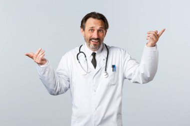 Covid-19, koronavirüs salgını, sağlık çalışanları ve pandemik konsept. Kararsız doktorun seçim yapma konusunda sorunları var. Parmakla göstererek varyantları işaret ediyor, sorunlu görünüyor.