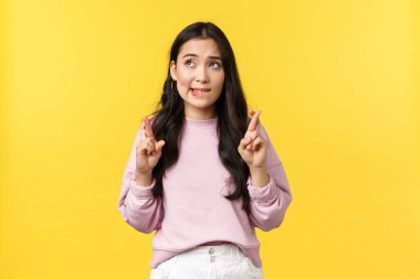 İnsan duyguları, yaşam tarzı ve moda kavramı. Umut dolu Asyalı kız öğrenci sınavı geçebilir ya da üniversiteye girebilir, şans dileyip dudağını ısırabilir, sol üst köşeye bakıp dilek tutabilir.