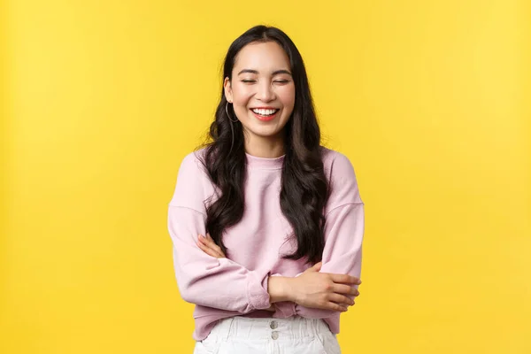 As pessoas emoções, estilo de vida e conceito de moda. Menina coreana alegre de boa aparência se divertindo, rindo alto e se sentindo feliz, de pé alegre sobre fundo amarelo — Fotografia de Stock