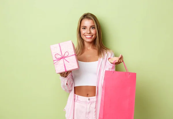 一个迷人的女孩站在绿树成荫的背景上庆祝节日、购物和买礼物的画像 — 图库照片