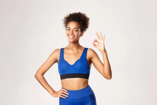 Midjan upp av nöjda afrikanska-amerikanska friska fitness kvinna, visar okej tecken på godkännande, ler nöjd, rekommendera något. Begreppet träning och idrott — Stockfoto