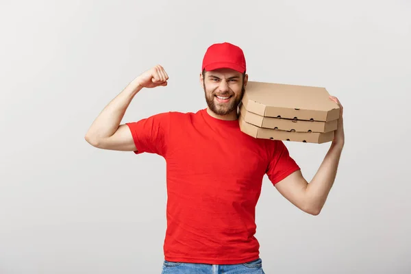 Concepto de entrega - Retrato de un hombre fuerte y guapo repartidor flexionando su músculo y sosteniendo paquetes de cajas de pizza. Aislado en Grey studio Background. Copiar espacio. —  Fotos de Stock